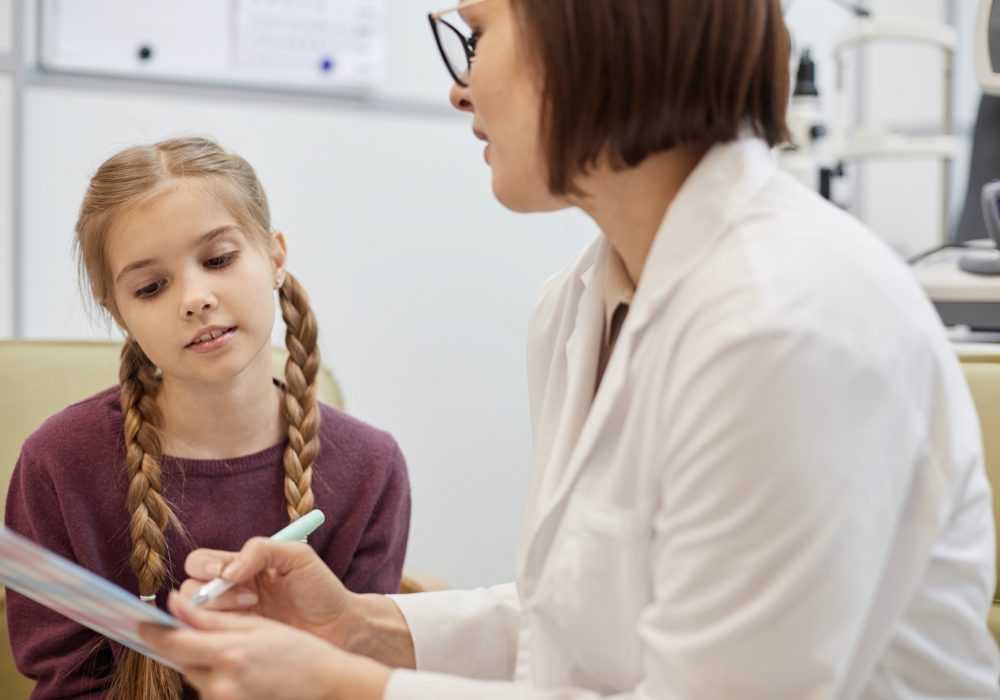 Female Ophthalmologist Talking to Little Girl